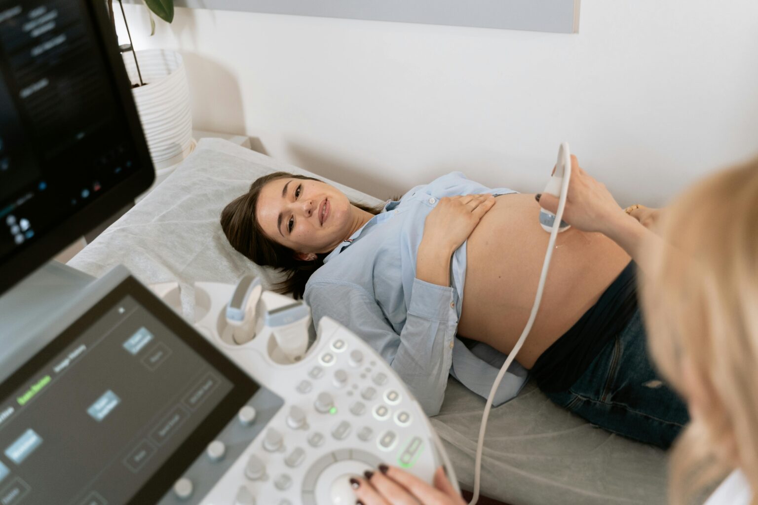 A pregnant woman getting an ultrasound at the hospital or OB/GYN office.